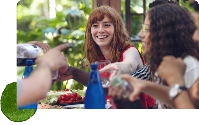 Group of people smiling sharing a meal