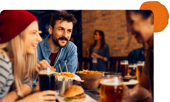 Group of people smiling sharing a meal at restaurant